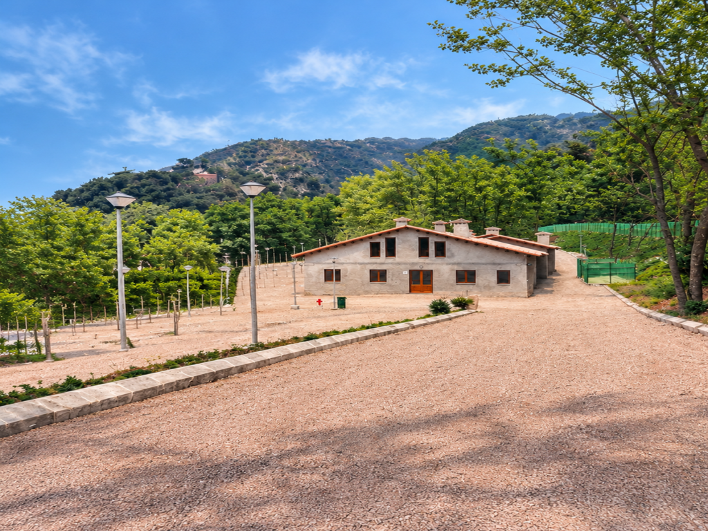La nostra història La masia del Càmping L'Avencó amb el Montseny al fons
